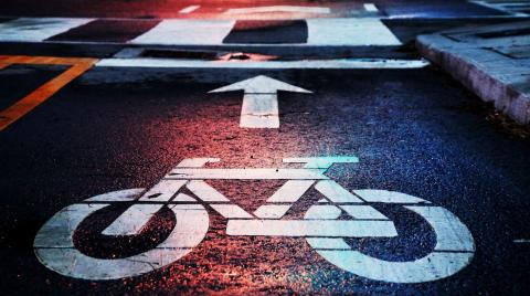 A bicycle road marking with a large 'forward' arrow