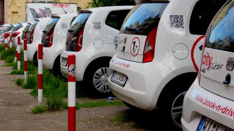 A row of white vehicles parked in a lot.