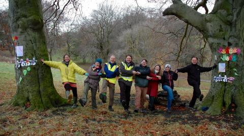 Social benefits including increased social capital, civic participation and inclusion. Photo: Sunderland Local Ambassadors Gathering - Flickr.com/permaculture-association People standing holding hands between two trees