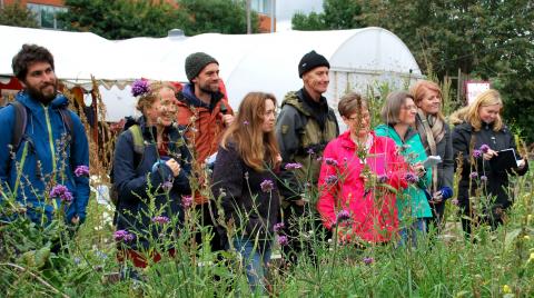 People standing behind flowering plants