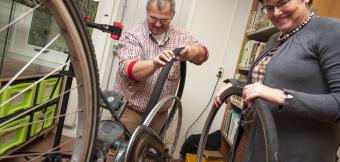 Man and woman at a repair cafe fixing a bike