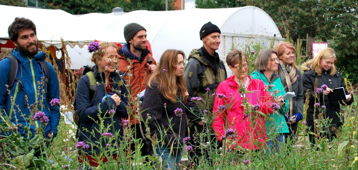 People standing behind flowering plants