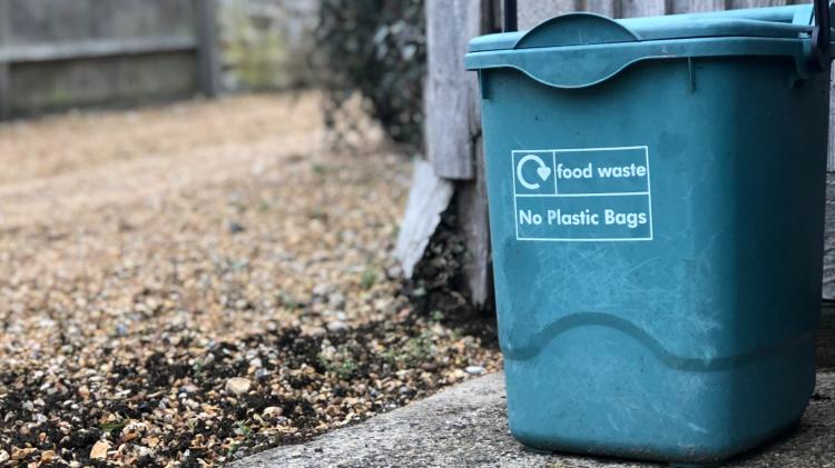 A small caddy is all you need to collect compost. Or use an old cereal box. Photo by Patricia Valerio - unsplash A compost caddy next to a gravel path