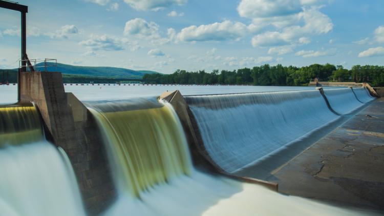 Renewable energy comes from everlasting sources like wind, water, sunshine or plants and produces minimal CO2. Photo: american public power association - unsplash.jpg Hydropower Damn with water falling over edge against blue skies