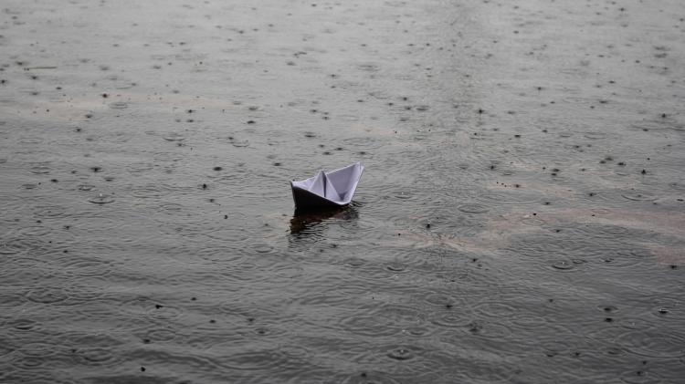 Small Paper Boat Floating in Rain Water