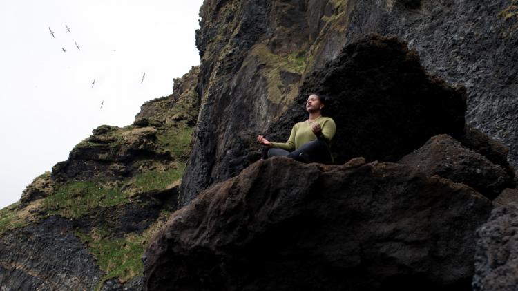 Take time to breathe - you don’t have to join a meditation class to feel the benefits of taking time out. Photo: tolu bamwo - nappy.co Person in Zen pose outside a cave with sky behind them.