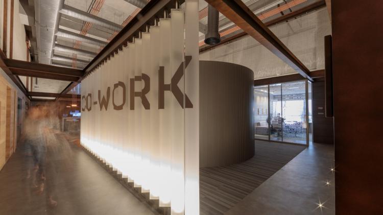 An office environment with a wall that reads "co-work".