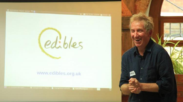 Man standing in front of a powerpoint that reads "edibles"