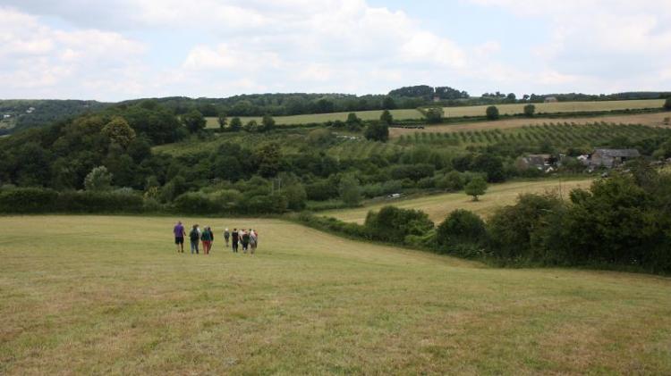An ethical approach based on compassion, humility and reverence for nature. Photo: https://www.flickr.com/photos/permaculture-association/6325742696/ People walking in a field is farm and field lands in the background