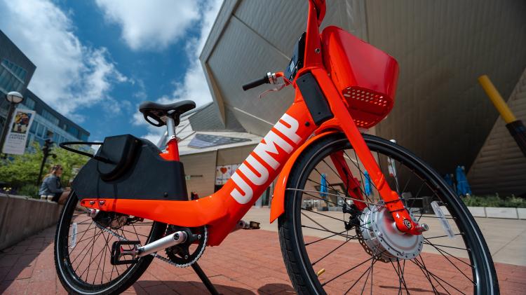 Red electric bike on pavement with blue sky in background