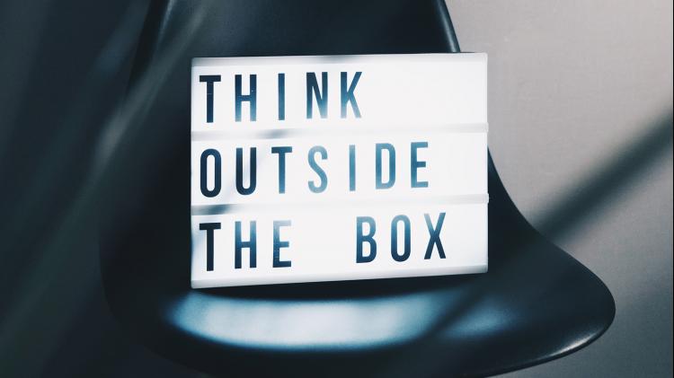 Light box saying 'think outside the box' sitting on a chair