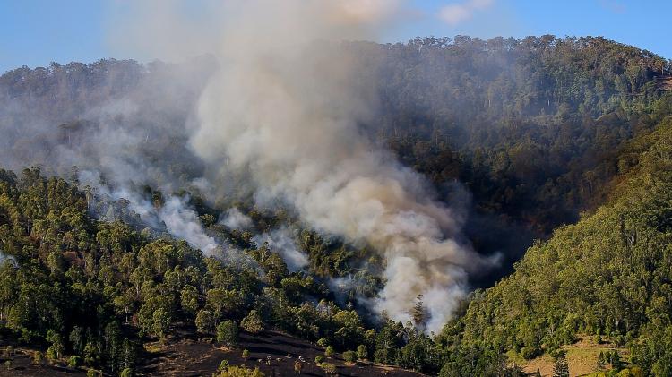 Wildfires will usually move uphill, especially on dry, south facing slopes. Credit: sandid - pixabay.com https://pixabay.com/photos/fire-smoke-bushfire-bush-scrub-671555/ Smoke form a wildfire running up a forested slope