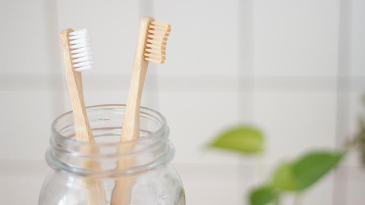 Two bamboo tooth brushes in a glass jar