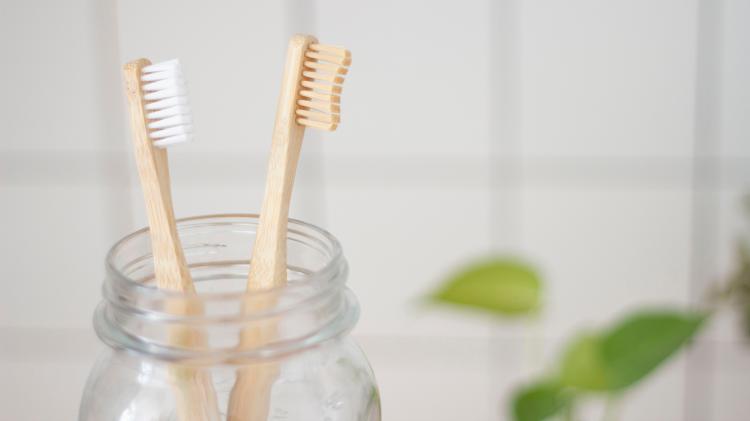 Turning the tap off while brushing your teeth is a simple way to save water. Photo: Superkitina - unsplash.com Two bamboo tooth brushes in a glass jar